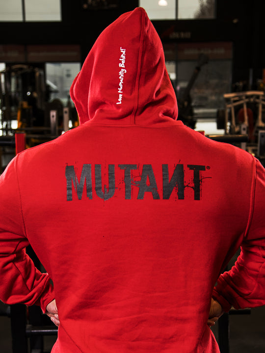 Back view of an athlete posing in the gym, wearing the Red Mutant Patched Zip-Up Gym Hoodie. The hoodie features a black Mutant logo on the back and the white Mutant motto 'Leave Humanity Behind' on the hood.